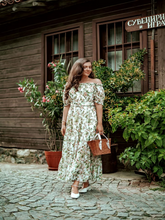 A woman wears a silk floral dress
